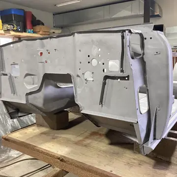 Body tub blasted to bare metal and sitting on a stand