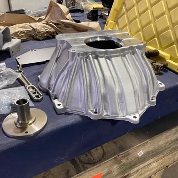 Bellhousing and driveline parts laid out on the bench